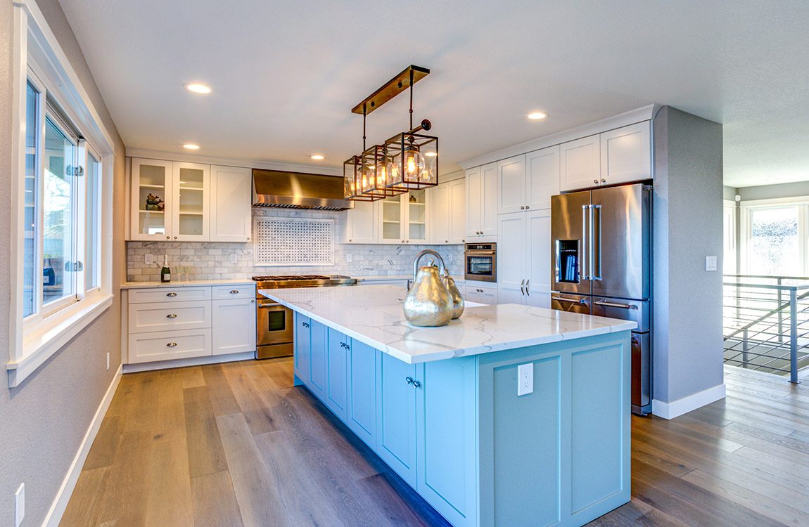 Beautiful kitchen room with green island and double door refrigerator.